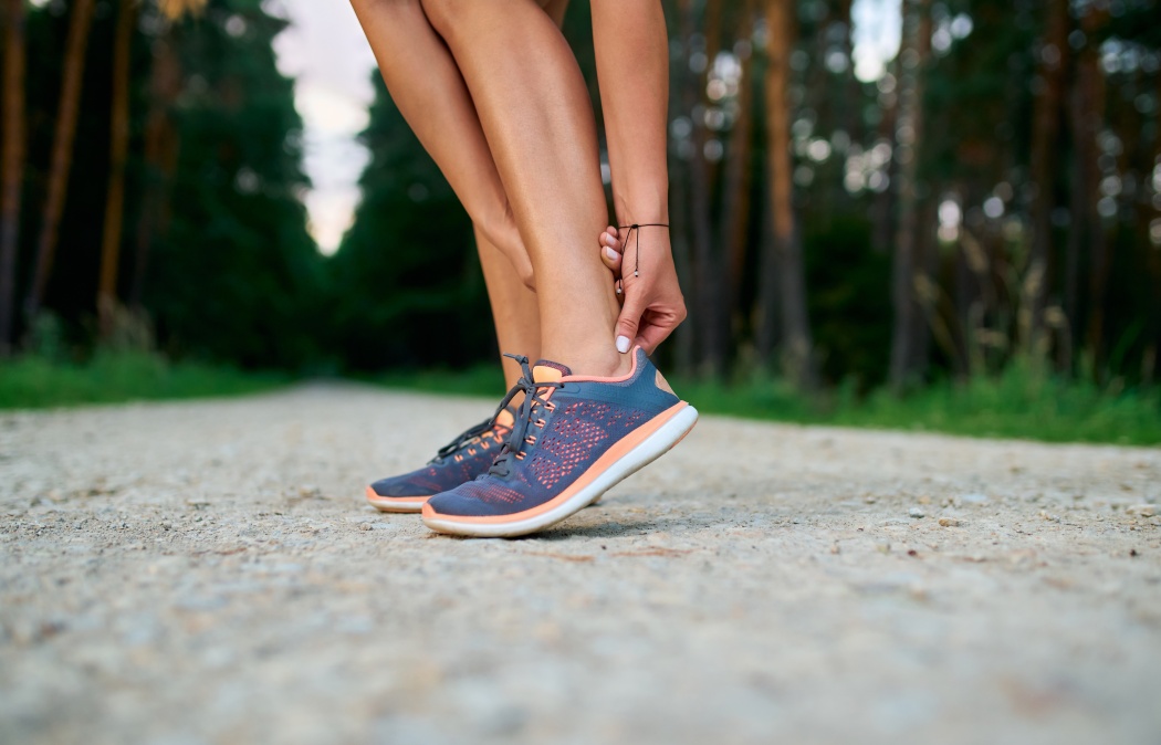 Close-up of female runner touching achilles tendon. Achilles tendonitis injury